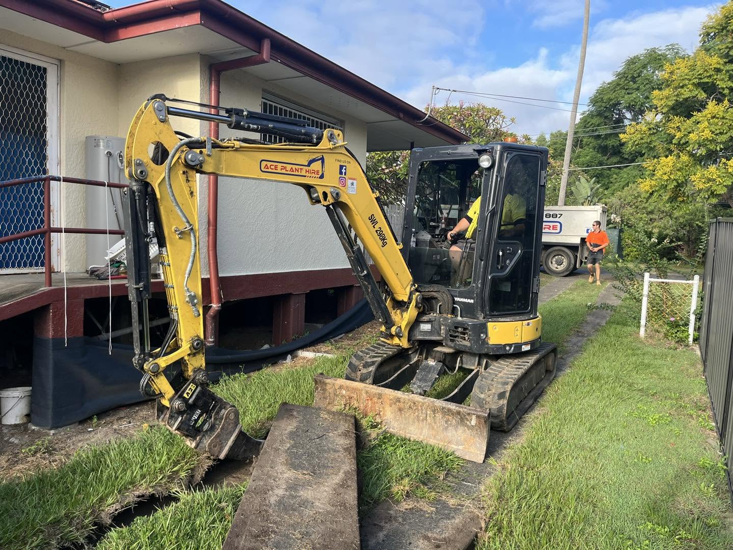 Mini excavator positioned beside house for excavation