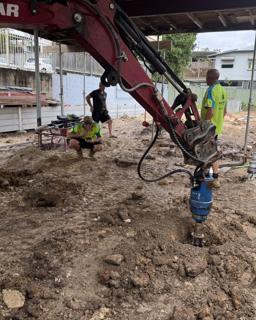 Excavator with auger drilling pier holes