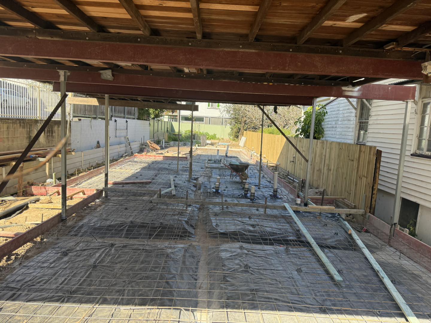 Rebar mesh and membrane under raised house for slab pour