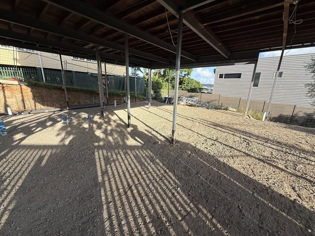 Compacted gravel base under steel shed frame
