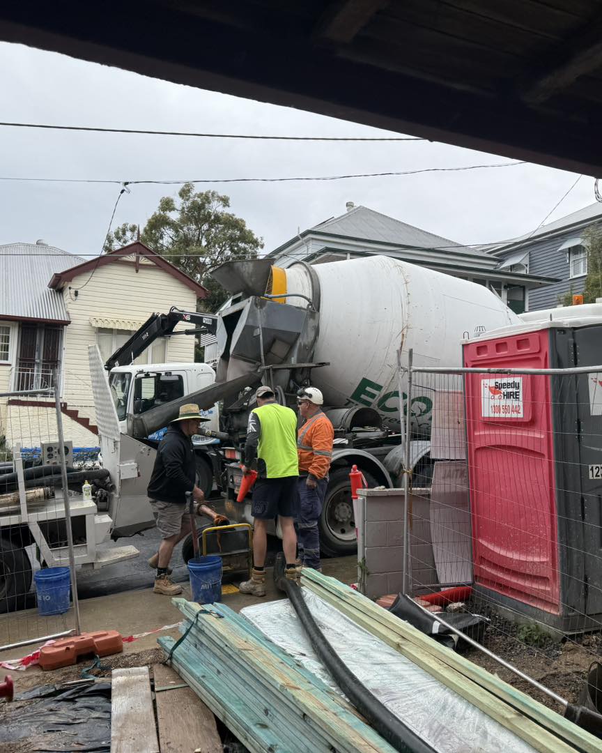 Team managing pump hose during concrete pour